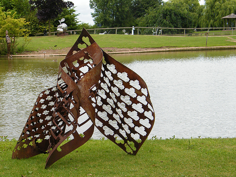 Metal sculpture title Family viewed by lake
